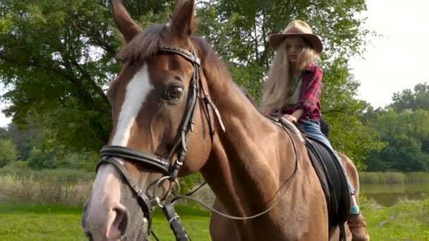 Jung cowgirl im hut reiten sie pferd — Stockvideo