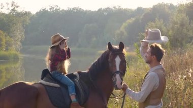 Kovboy ve kızı at sırtında