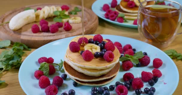 甘い蜂蜜パンケーキの上に注ぐ。おいしい朝食料理 — ストック動画