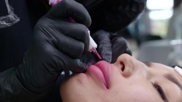 Татуировка на губе с микролезвием со специальным красящим пигментом, который корректирует цвет губ в косметологической клинике — стоковое видео