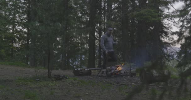 Vousatý turista u ohně v lese. — Stock video