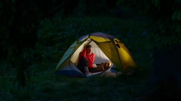 Un uomo in una tenda nella foresta di notte — Video Stock