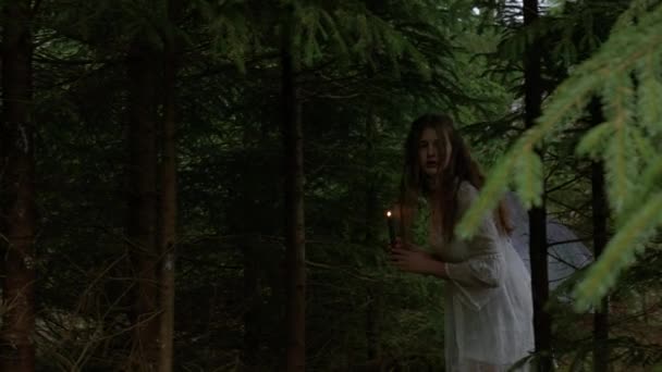 Эльфийская девушка со свечой гуляет по лесу — стоковое видео