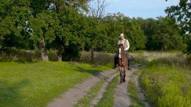 Genç kovboy ormanda at sırtında