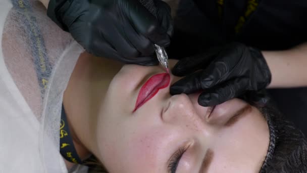 Tatouage à lèvres Microblading avec un pigment colorant spécial qui corrige la couleur des lèvres dans la clinique de cosmétologie — Video