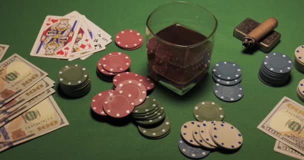 Chipsy, karty, szklanka whisky i pieniądze są na zielonym stole do gier. — Wideo stockowe