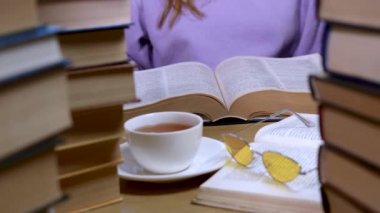 Kadın eli bir kitabın sayfalarını çeviriyor, yakın plan.