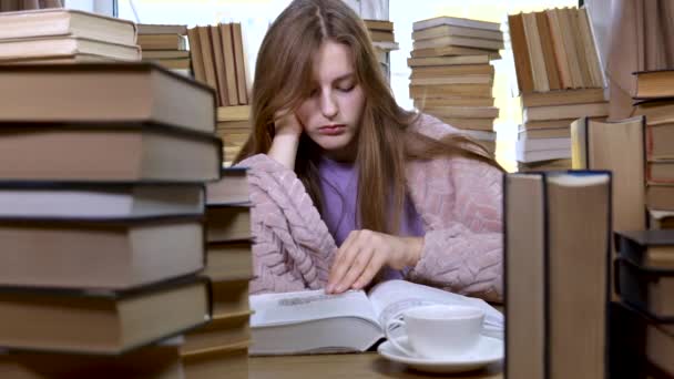 Ein Mädchen liest in der Bibliothek ein Buch — Stockvideo