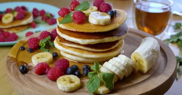 Pancakes are served with raspberries, banana, blueberry and mint leaf — Stock Video