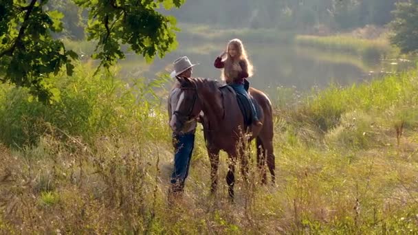 Cowboy und seine Tochter zu Pferd — Stockvideo