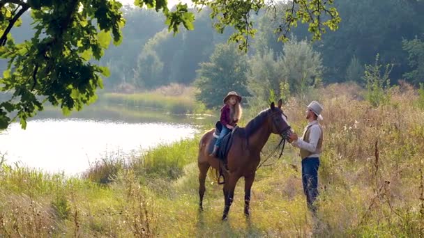 Cowboy och hans dotter till häst — Stockvideo