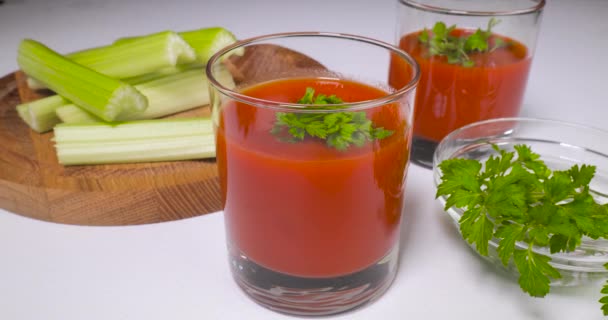 Copos de suco de tomate na mesa — Vídeo de Stock