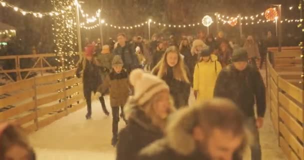 Menschen laufen in der Winternacht unter freiem Himmel auf der Eisbahn — Stockvideo