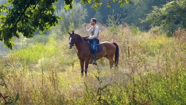 Americký kovboj na koni na lesním trávníku — Stock video