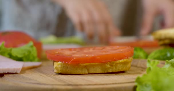 Chef femenino en la cocina de la casa recoge un sándwich — Vídeos de Stock