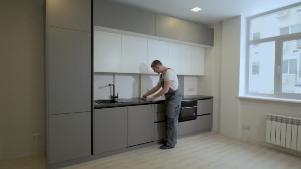 建築者はキッチン家具構造の寸法と設置品質をチェックします。 — ストック動画