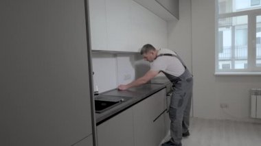 İnşaatçı mutfak mobilyalarının boyutlarını ve kalitesini kontrol eder.
