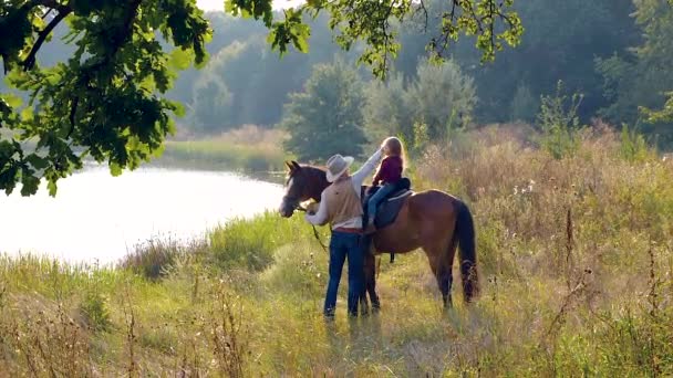 Vaquero y su hija a caballo — Vídeos de Stock