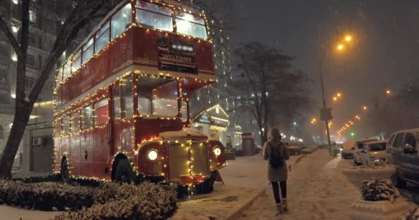 Κόκκινο λεωφορείο διπλό κατάστρωμα και βαριά χιονόπτωση το βράδυ των Χριστουγέννων — Αρχείο Βίντεο