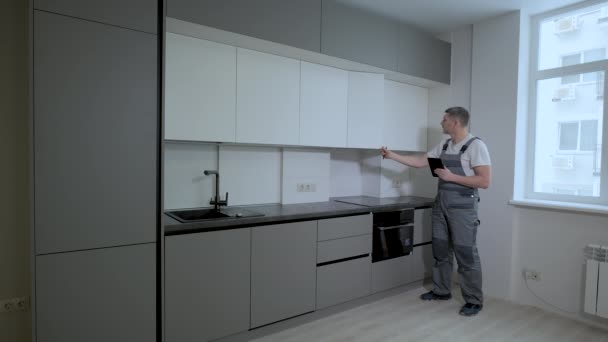 El constructor comprueba la calidad de la instalación de la construcción de muebles de cocina — Vídeo de stock