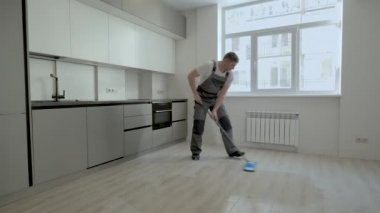 Üniformalı bir müteahhit yeni bir dairede yerleri yıkıyor.