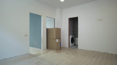 Profesyonel bir işçi yeni bir daireye kutu taşır.