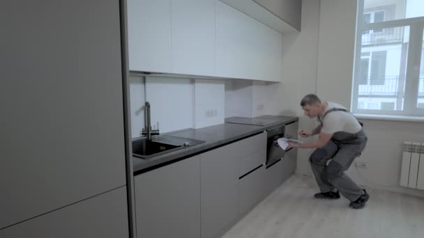 Il costruttore controlla la qualità dell'installazione della costruzione di mobili da cucina — Video Stock