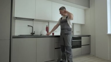 İşçi dinleniyor ve yeni mutfakta çay içiyor.