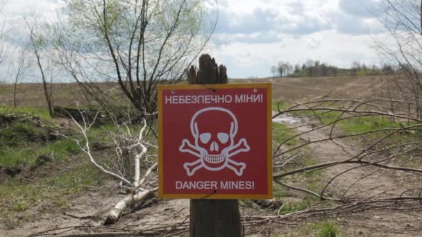 Een bord met een inscriptie in het Oekraïens en Engels Gevaar van mijnen — Stockvideo