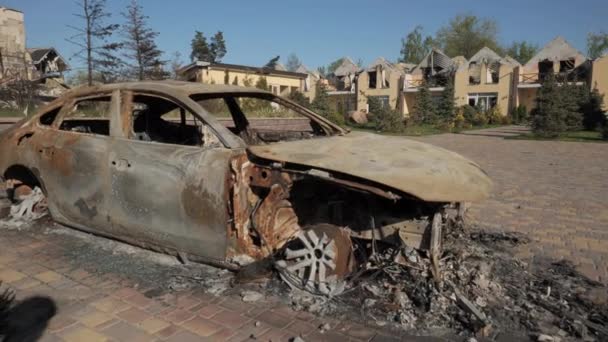 Egy felgyújtott autó és lerombolt házak eredményeként tüzérség vagy rakéta tűz az orosz hadsereg a kijevi régióban — Stock videók