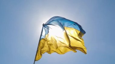 The Ukrainian flag flutters against the blue sky