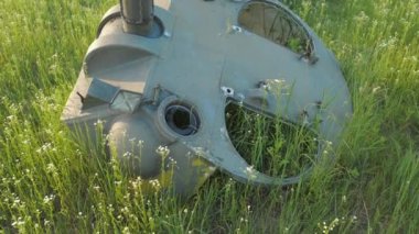Kyiv yakınlarındaki bir tarlada yanmış bir tankın kalıntıları. Çimenler ve bahar çiçekleri tankın kalıntılarının etrafında yetişir. Savaş bittikten sonra yeni bir hayata başlama kavramı..