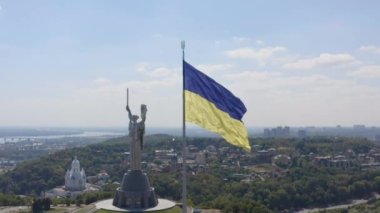 Ukrayna 'nın başkenti Kyiv' de Kiev Anavatanı 'nın hava manzarası ve Ukrayna bayrağı dalgalanmaktadır. 4K
