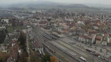 İsviçre 'nin Payerne kentindeki tren istasyonunun havadan görüntüsü. Tren raylarda. 4K
