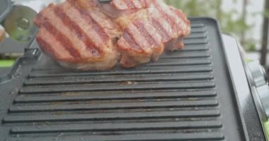 Biberiyeli lezzetli biftek elektrikli ızgarada pişirilir. Yıllanmış az pişmiş ızgara sığır filetosu taze mermer hassasiyet bifteği. Elektrikli kızartmada kızarmış et..