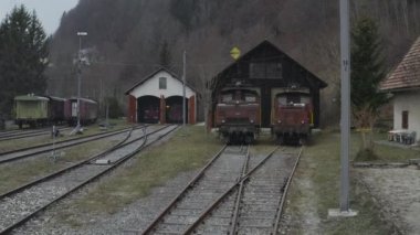 İsviçre, Alplerdeki bir tren istasyonunda Retro trenlerin hava görüntüsü. 4K