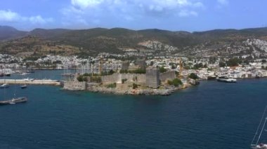 Türkiye 'deki Bodrum Kalesi' nin havadan görüntüsü. İnsansız hava aracı deniz körfezi ve kalenin üzerinde uçuyor. Bodrum, Türk Rivierası 'nda popüler bir turizm beldesi.
