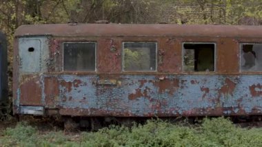 Aerial view of a retro train on the railway tracks. Camera movement along the rusty wagons of a narrow gauge railway