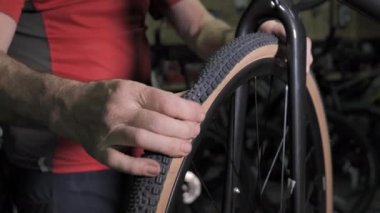 Bicycle mechanic pumping air into bike tire. Repair bike in cycling workshop. Bike maintenance, sport shop concept. Slow motion