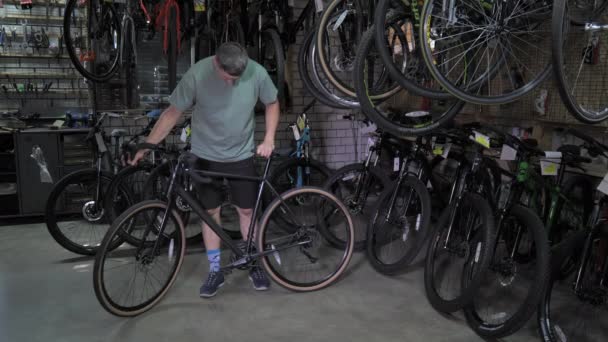Man Inspects Bicycle Purchase Bike Shop — Stockvideo