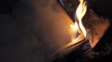An open book is on fire. Big bright flame, burning paper on old publication in the dark. Book Burning - Censorship Concept, slow motion, close-up, 4K