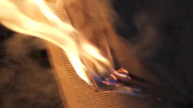 An open book is on fire. Big bright flame, burning paper on old publication in the dark. Book Burning - Censorship Concept, slow motion, close-up, 4K