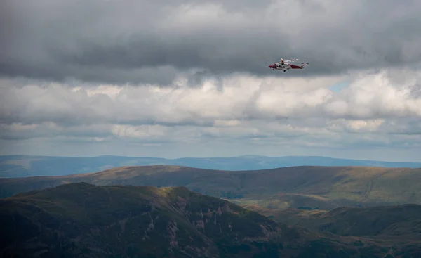 The Hm RescueGuard rescue helicopter, above Helvellyn Peak in the National Park Lake District 2022