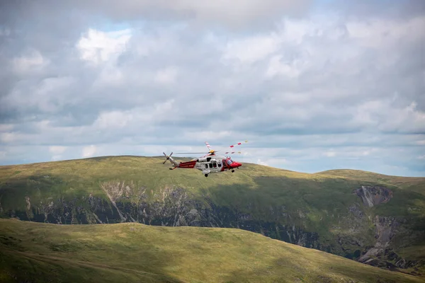 The Hm RescueGuard rescue helicopter, above Helvellyn Peak in the National Park Lake District 2022