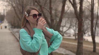 Parkta bir kız kahve içiyor..