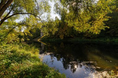 Nehir sonbahar ormanından akıyor. Sonbaharda gün batımından önce nehir