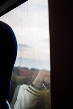 Düşüncelerimde, yolculuğun ortasında trende seyahat ederken kendi yansımamı gördüm.