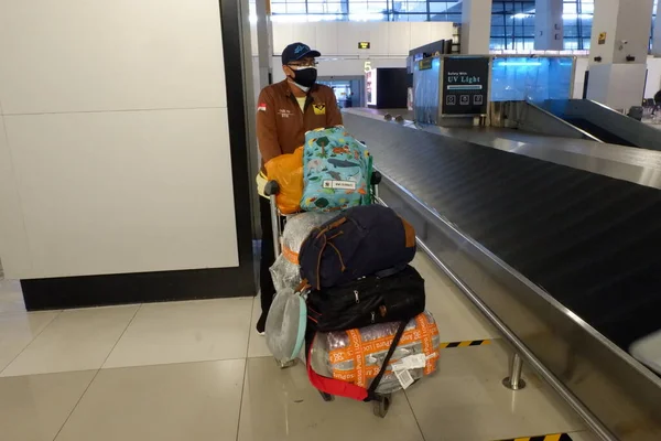 man with luggage and bag of coffee in the airport