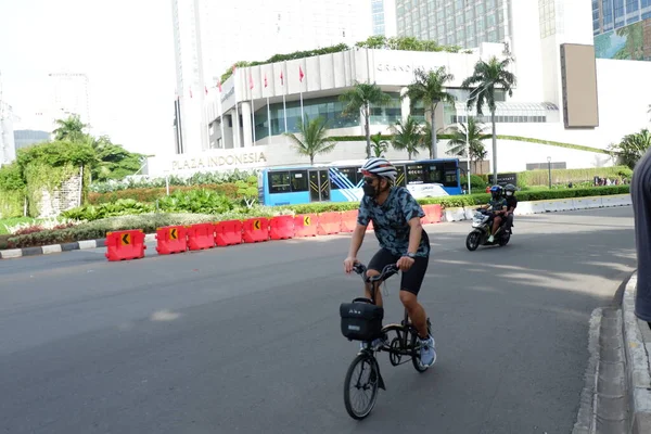 Şehirde bisiklet süren genç bir kadın.