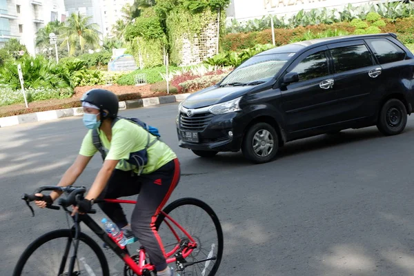 Şehirde bisiklet süren genç bir kadın.